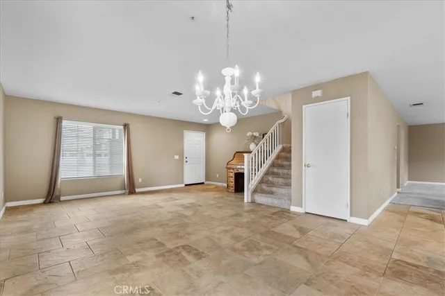 a view of a livingroom with a chandelier fan and windows