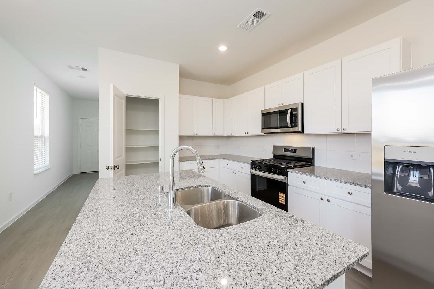 15243 Canyon Rapids Road Conroe, TX 77302 - Photo 6 of 15 a kitchen with granite countertop a sink a counter top space appliances and cabinets