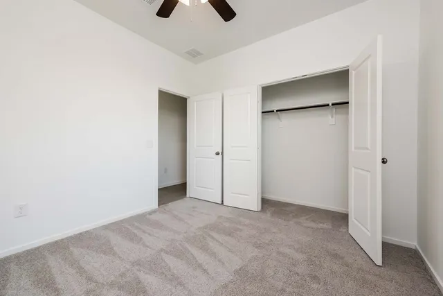 a view of empty room with ceiling fan