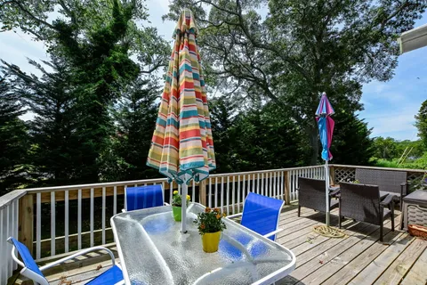 a view of a wooden deck with furniture and backyard