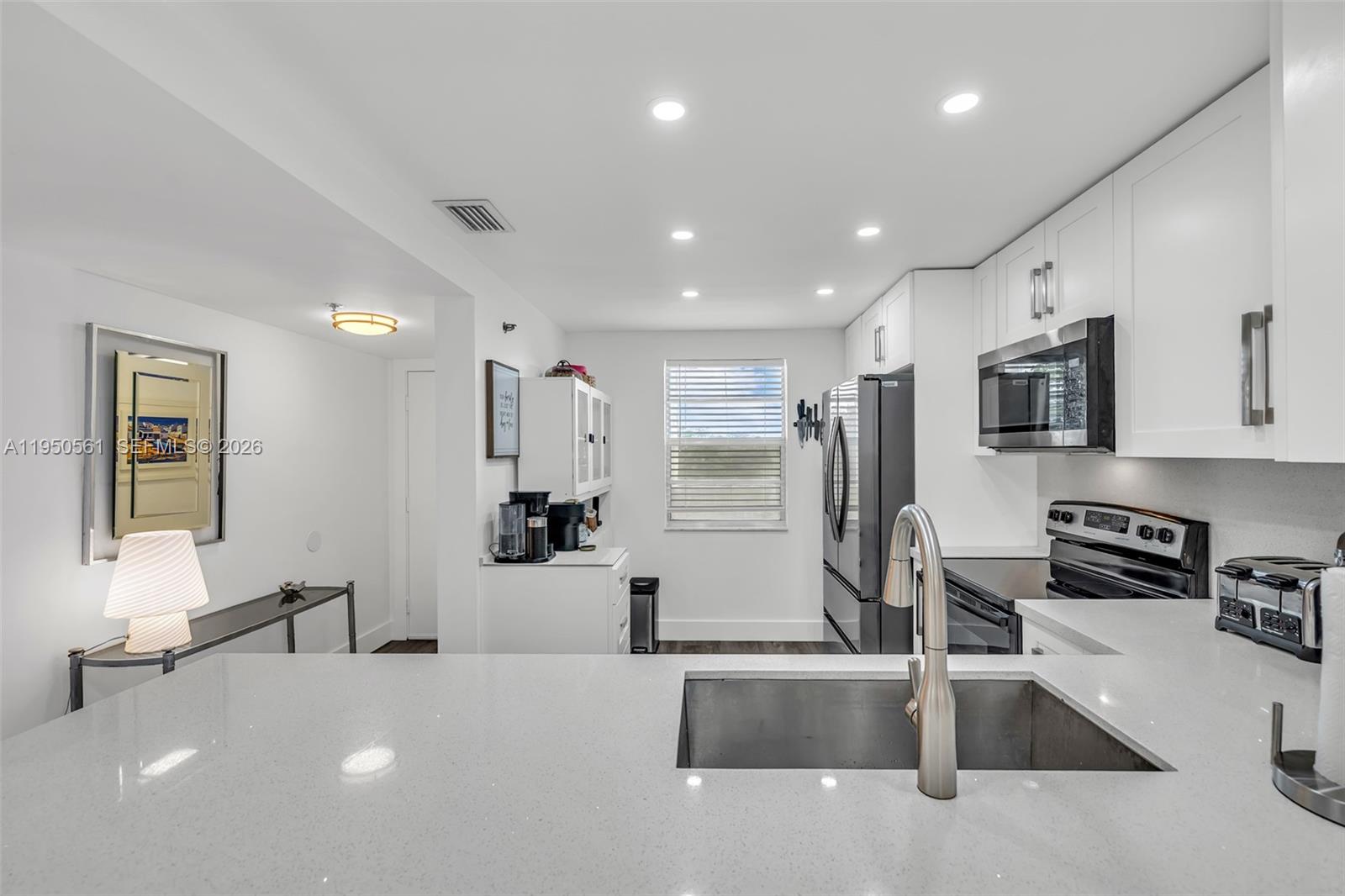 a large white kitchen with stainless steel appliances
