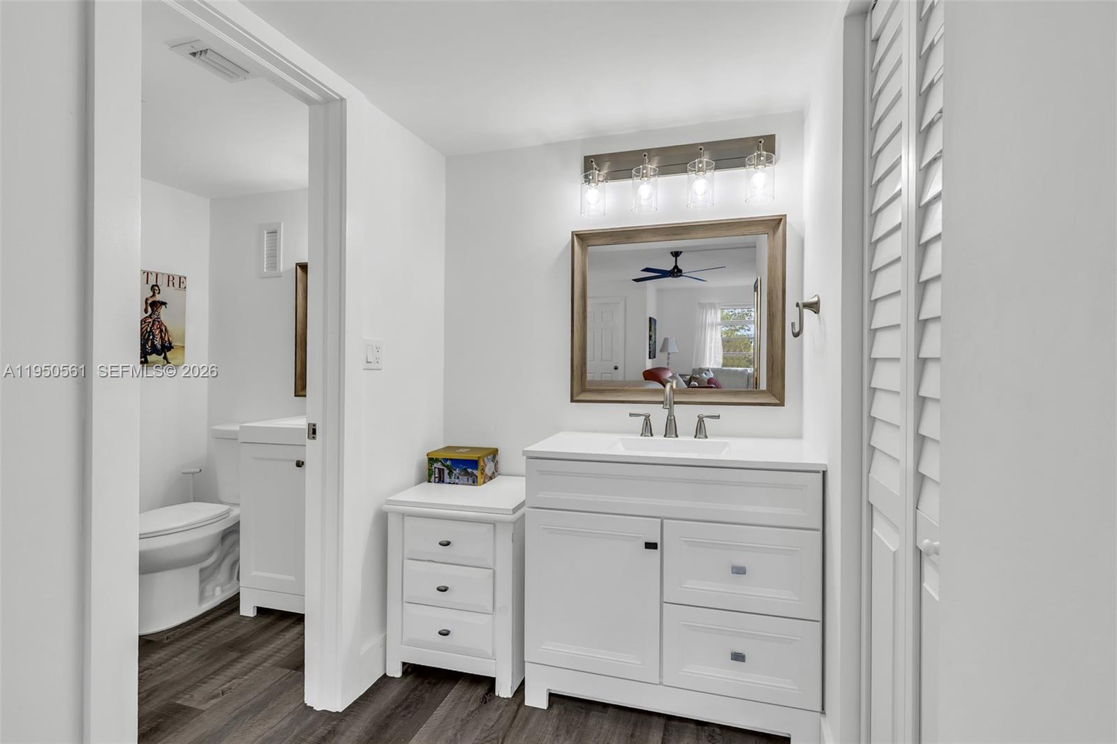 3910 Inverrary Boulevard, Unit 503B Lauderhill, FL 33319 - Photo 19 of 37 a bathroom with a granite countertop sink toilet a large mirror a vanity and a