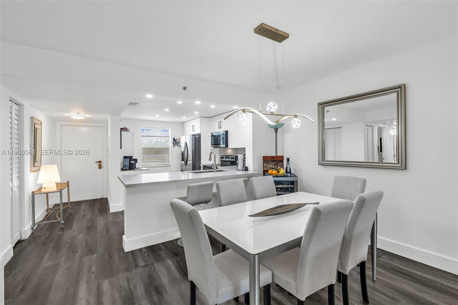 3910 Inverrary Boulevard, Unit 503B Lauderhill, FL 33319 - Photo 8 of 37 a view of a dining room and livingroom with furniture wooden floor a rug a chandelier