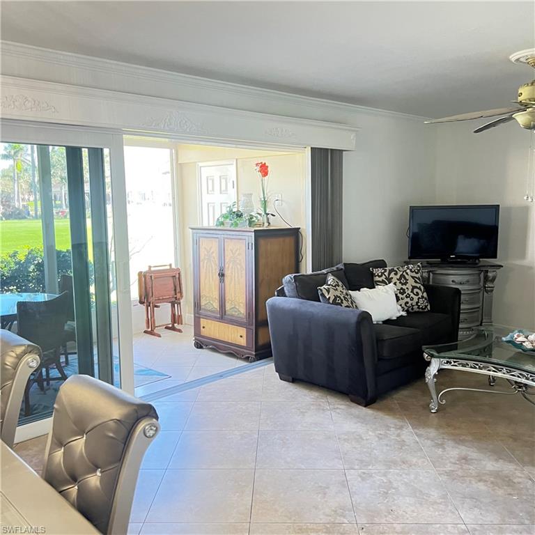 197 Harrison Road, Unit 3 Naples, FL 34112 - Photo 3 of 14 Living room featuring crown molding, light tile patterned floors, and ceiling fan