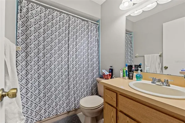 a bathroom with a granite countertop toilet and a sink
