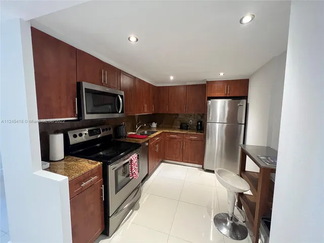 a kitchen with a refrigerator a stove top oven a sink and dishwasher