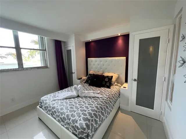 a bedroom with a large bed and a window