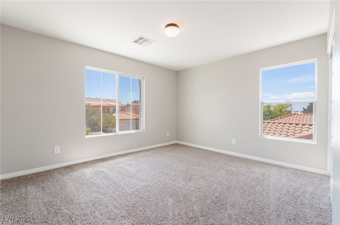 7857 Midnight Ride Street Las Vegas, NV 89131 - Photo 30 of 53 Carpeted empty room with healthy amount of natural light and baseboards