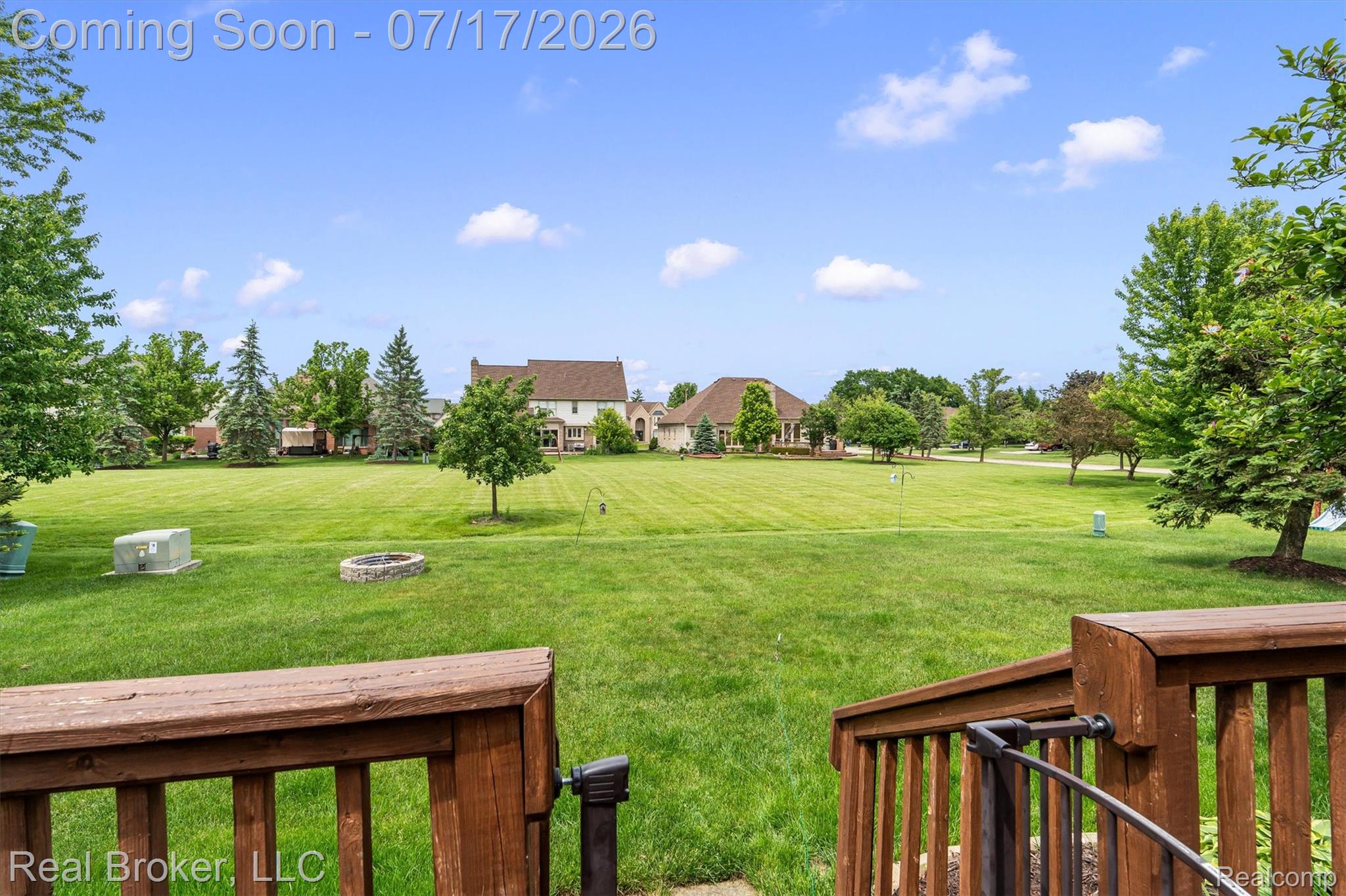 45192 Thornhill Road Canton, MI 48188 - Photo 33 of 34 Expansive grassy backyard featuring a built-in fire pit, mature perimeter trees, and a wood deck with stairs