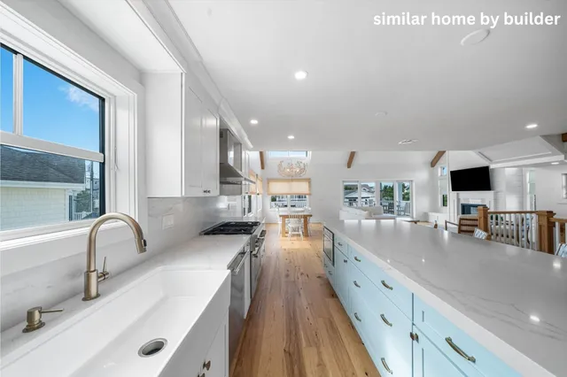 a living room with stainless steel appliances furniture and a kitchen view