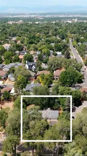 an aerial view of residential houses with outdoor space and trees