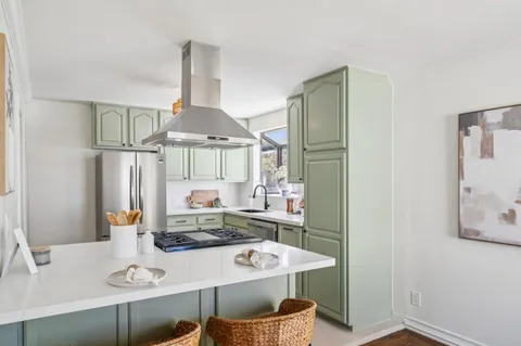 a kitchen with stainless steel appliances a stove a sink and a window