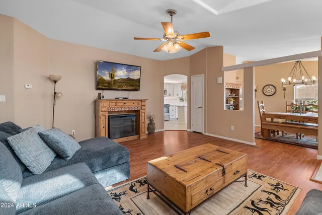 a kitchen with stainless steel appliances granite countertop a stove top oven a sink dishwasher and white cabinets with wooden floor