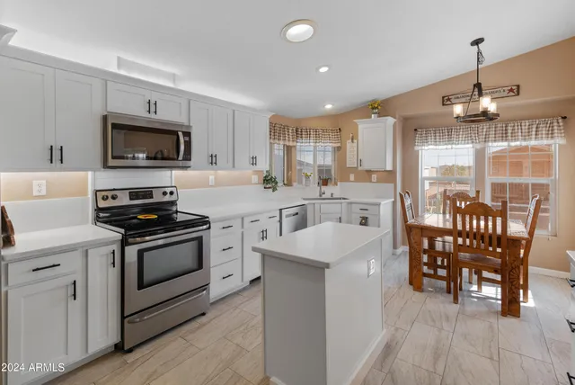 a kitchen with stainless steel appliances kitchen island granite countertop a stove a sink and a microwave