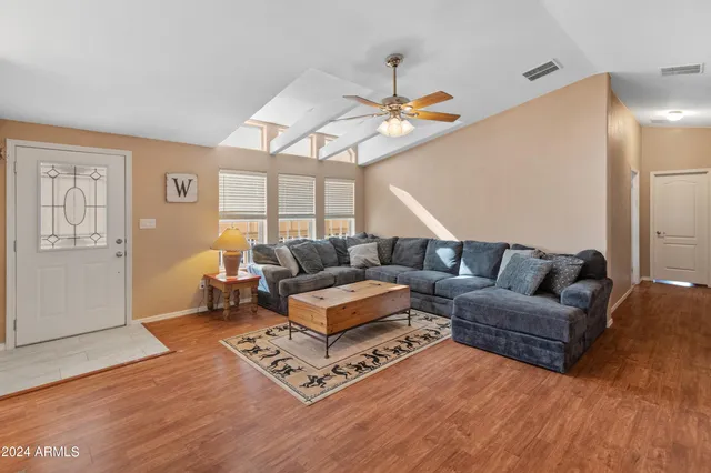 a living room with furniture a ceiling fan and a rug
