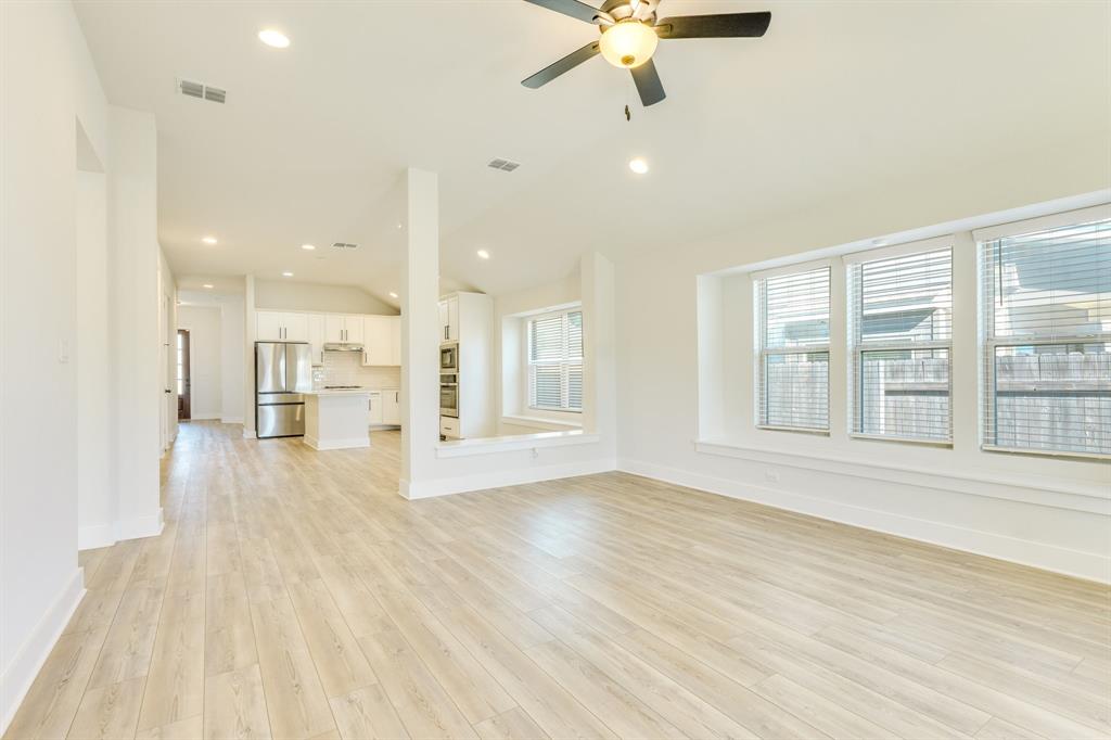 122 Biscayne Bay Bend Kyle, TX 78640 - Photo 12 of 29 an empty room with wooden floor and windows