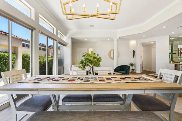 a dining room with furniture large windows and wooden floor