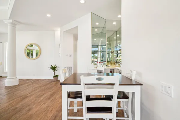 a kitchen with stainless steel appliances granite countertop a stove a refrigerator a sink a stove and white cabinets with wooden floor