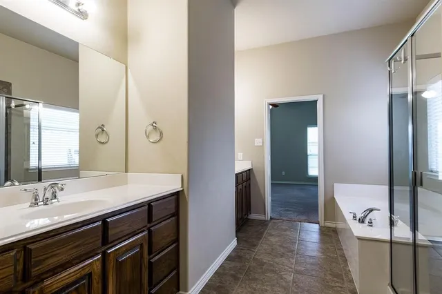 a spacious bathroom with a double vanity sink and a mirror