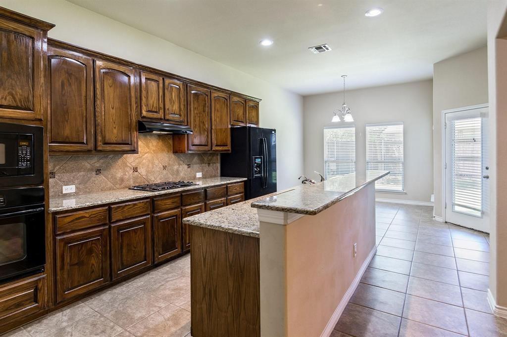 10104 Waterstone Way McKinney, TX 75072 - Photo 3 of 29 a kitchen with stainless steel appliances granite countertop a sink stove and refrigerator