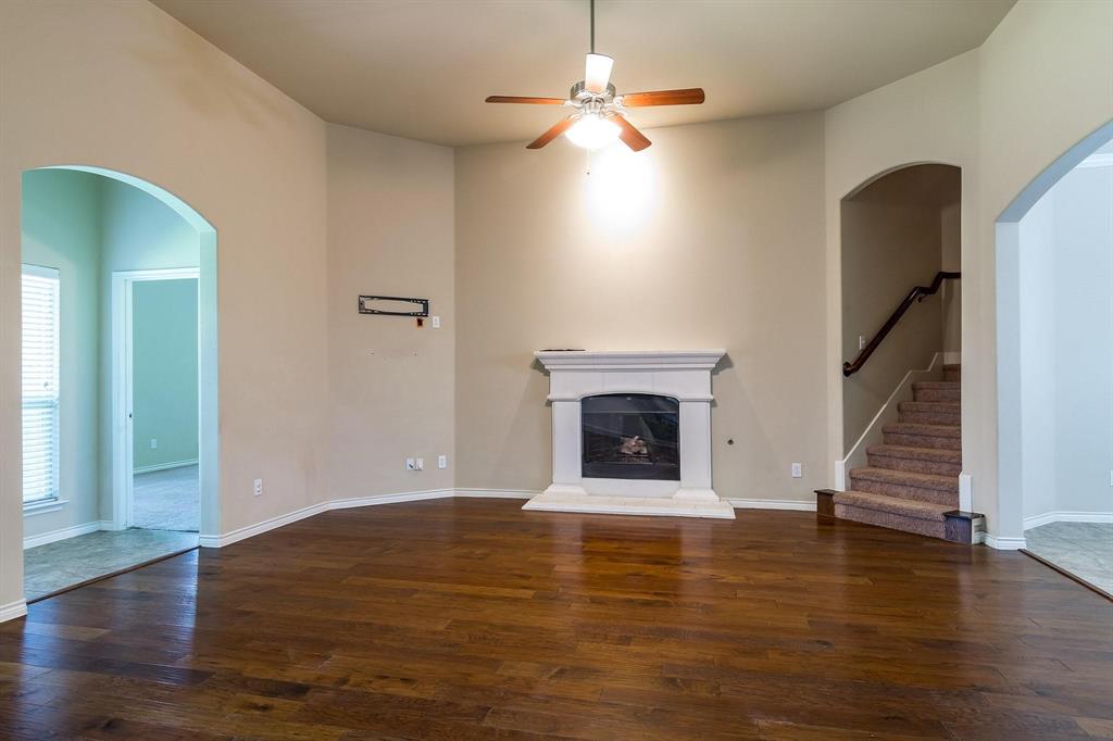 10104 Waterstone Way McKinney, TX 75072 - Photo 6 of 29 a view of an empty room with wooden floor fireplace and a window
