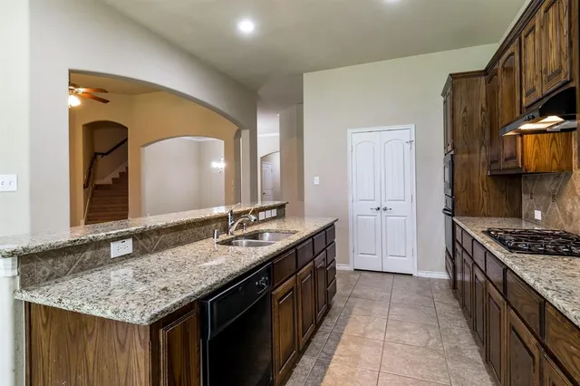 a kitchen with granite countertop a sink and cabinets