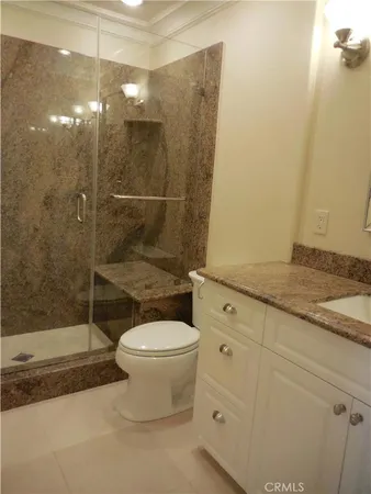 a bathroom with a granite countertop sink toilet and shower