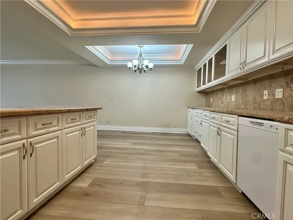 a large kitchen with stainless steel appliances wooden floors and view living room