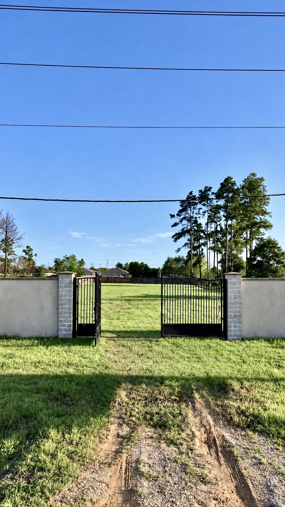 1229 County Road 5100 Road Cleveland, TX 77327 - Photo 6 of 16 Charming gated entrance leads to a spacious, lush green lot, perfect for building your dream home amidst serene surroundings.