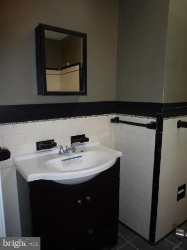 3905 Bonner Road Baltimore, MD 21216 - Photo 11 of 17 a bathroom with a sink vanity and mirror