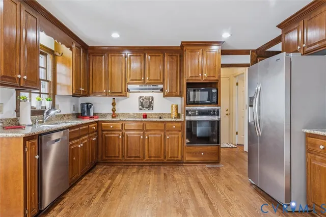 a kitchen with a refrigerator a sink and wooden cabinets