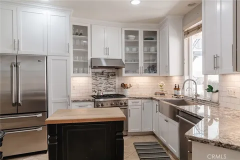 a kitchen with stainless steel appliances a sink stove and refrigerator