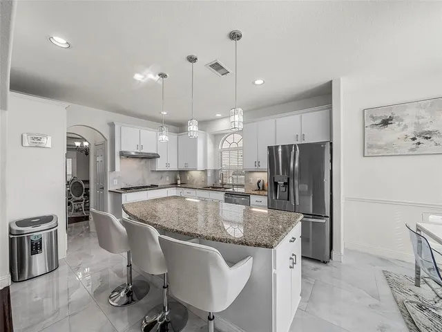 a kitchen with granite countertop cabinets a sink a window and stainless steel appliances