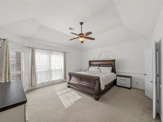 a bedroom with a large bed and a flat screen tv