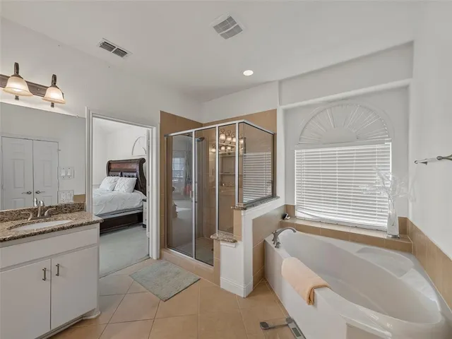 a en suite bathroom with a double vanity sink and a mirror