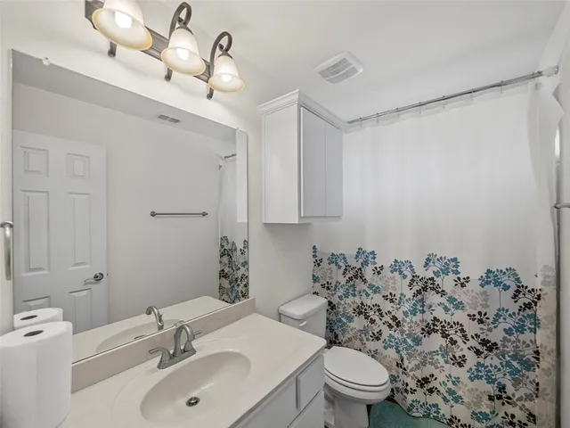 a bathroom with a toilet sink shower and mirror