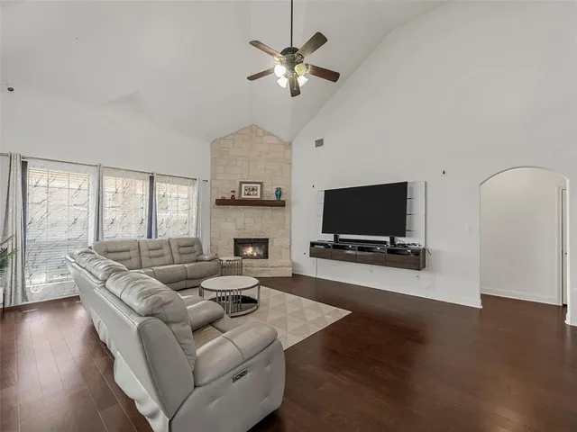 a living room with furniture a fireplace a flat screen tv and a large window