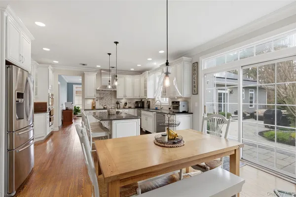a view of a dining room and livingroom with furniture wooden floor a chandelier