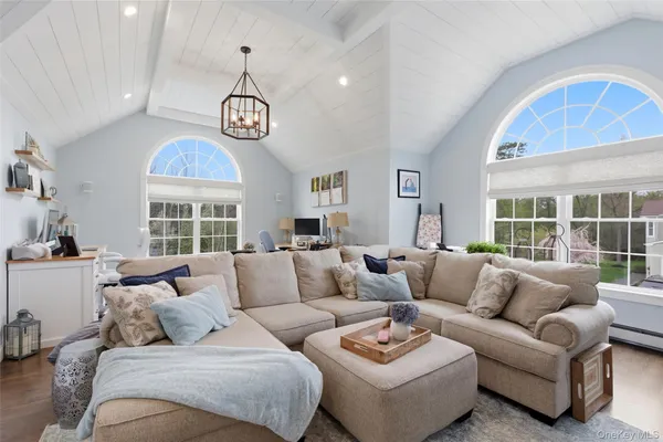 a living room with furniture a chandelier and a large window
