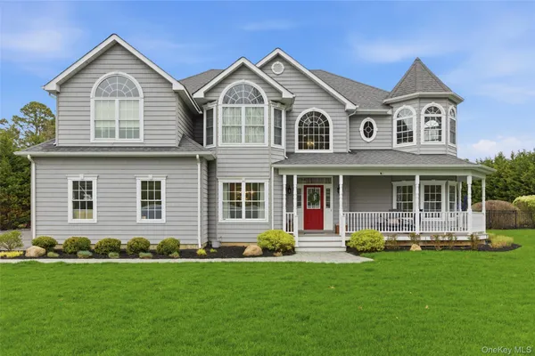 a front view of a house with a yard and green space