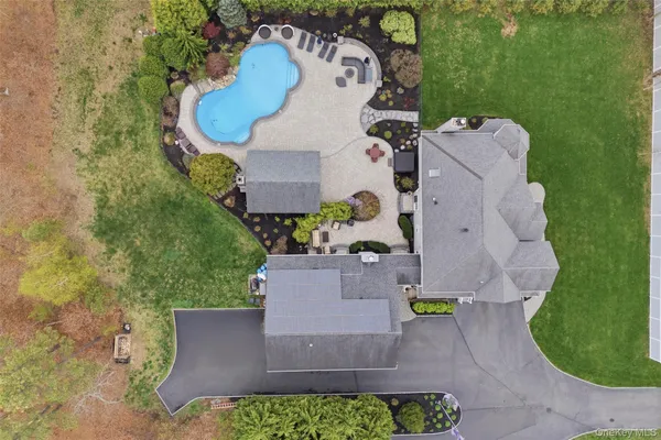 an aerial view of a house with a swimming pool and garden