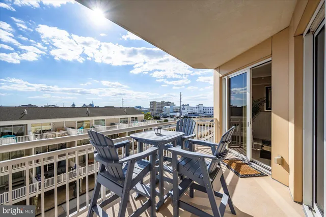 a kitchen with stainless steel appliances kitchen island granite countertop a table chairs and a refrigerator