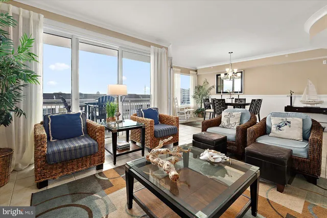 a living room with furniture a chandelier and a large window