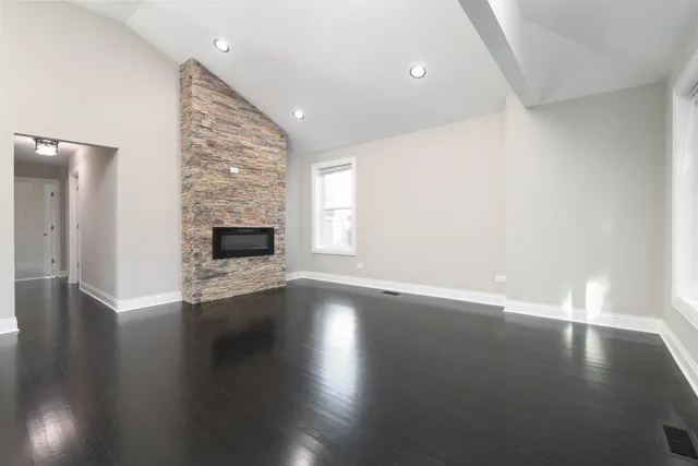 an empty room with wooden floor and fireplace