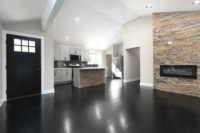 a view of kitchen with granite countertop stainless steel appliances and wooden floor