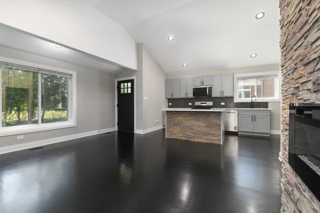 an open kitchen with kitchen island and a stove top oven