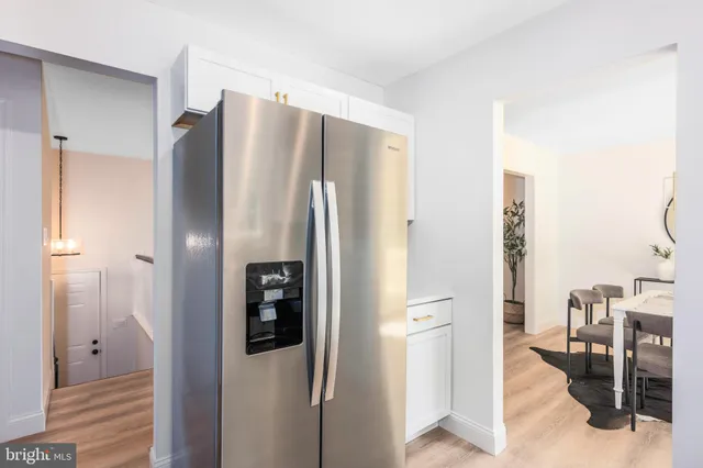 a view of a kitchen with refrigerator and wooden floor