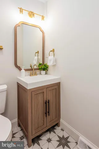 a bathroom with a sink vanity mirror and toilet