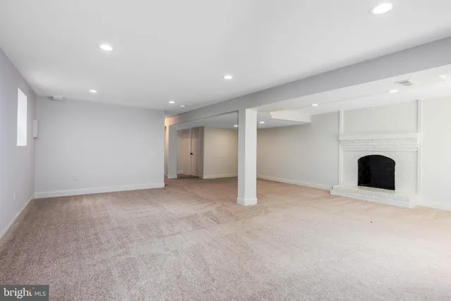 an empty room with fireplace and a window