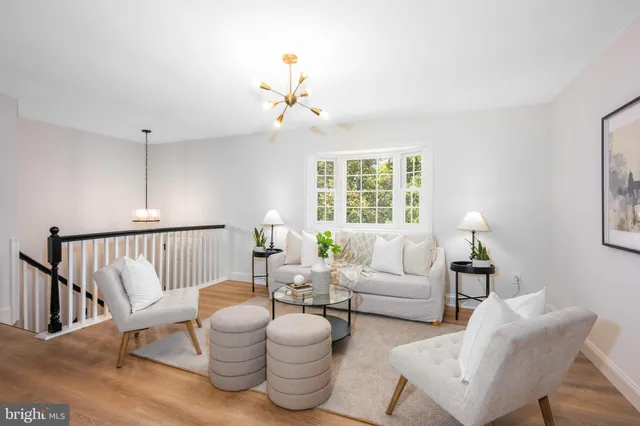 a living room with furniture a chandelier and a window